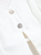 White backless halter neck camisole top with two light buttons, smooth fabric, refined stitching.