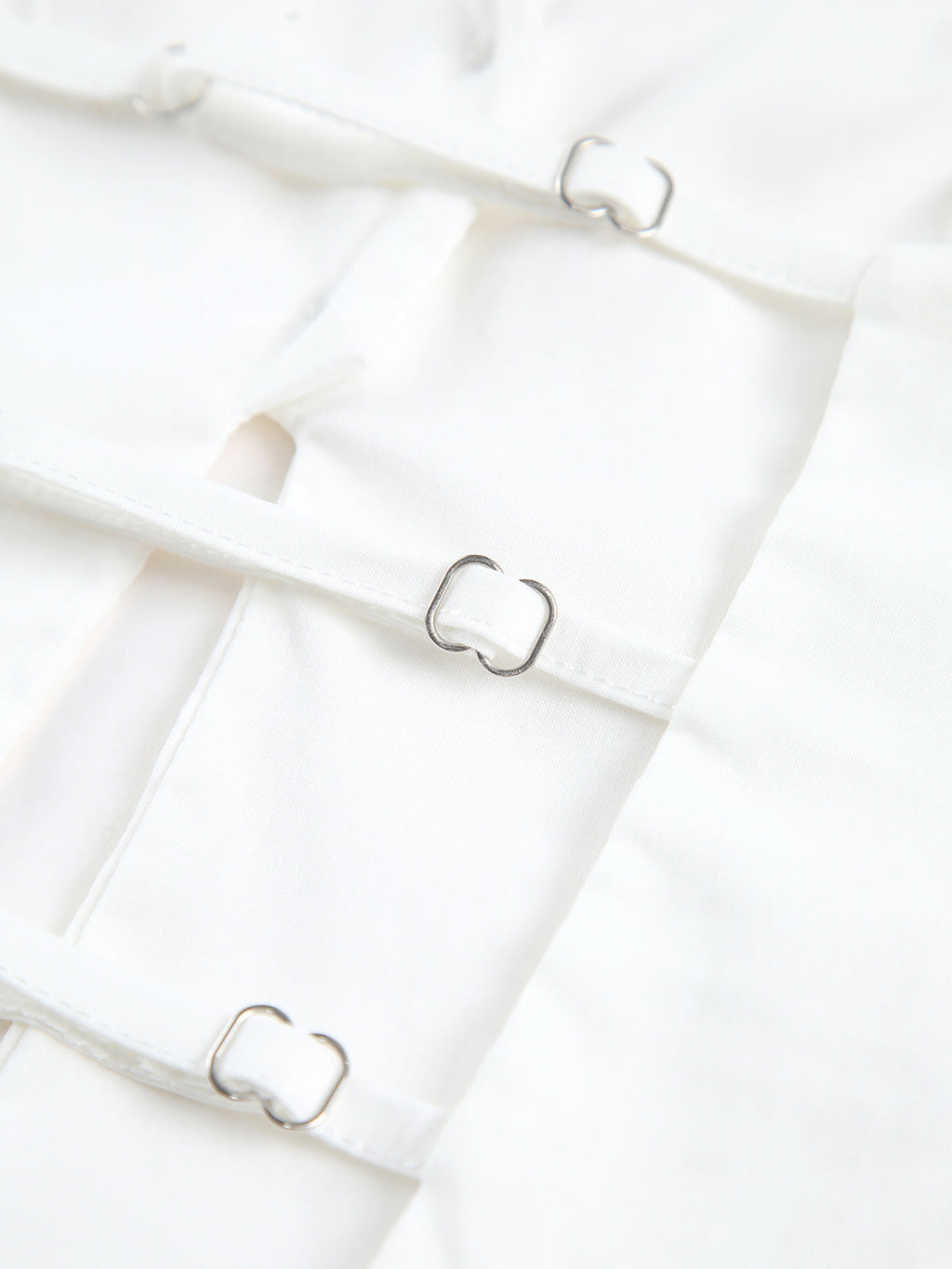 Backless halter neck camisole top with thin straps, square silver buckles, smooth fabric.