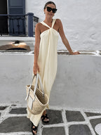 A creamy long halter gown with elegant draping and a sophisticated silhouette.