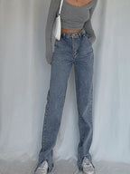 Classic straight leg denim jeans and a fitted gray long-sleeve crop top are worn.