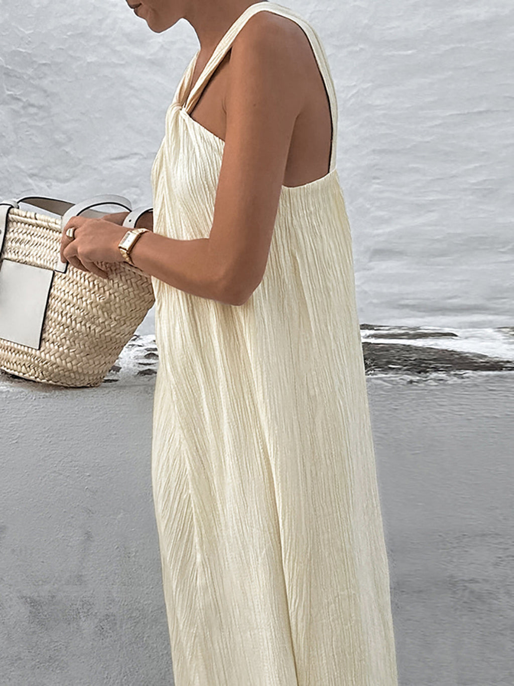 A creamy long halter gown by LA FINE FLEUR, featuring an elegant, flowing silhouette.
