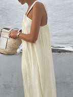 A creamy long halter gown by LA FINE FLEUR, featuring an elegant, flowing silhouette.