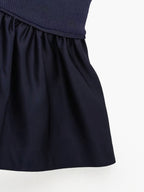 Navy blue ribbed knit camisole crop top with gathered ruffles and a slight sheen.