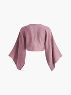 A long sleeve cropped tie-front blouse in crinkled pink gauze with wide, relaxed sleeves.