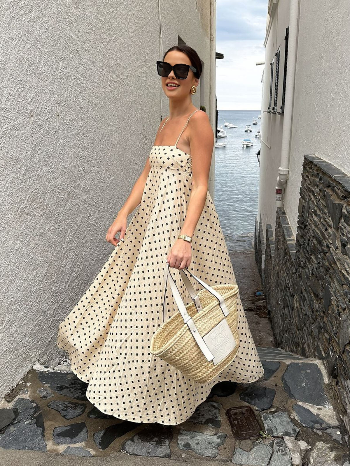 A patterned LA FINE FLEUR spaghetti strap maxi dress with a flowing silhouette.