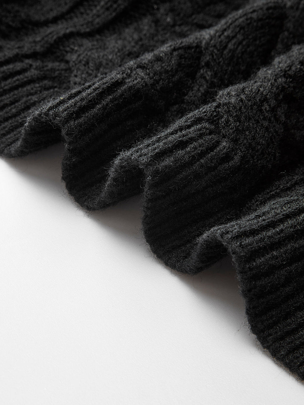 Ribbed hem of the LA FINE FLEUR cable knit cardigan with bow-knot accent, wavy edge.