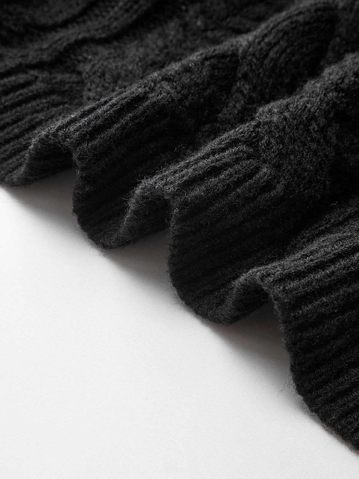 Ribbed hem of the LA FINE FLEUR cable knit cardigan with bow-knot accent, wavy edge.
