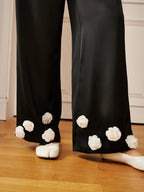 LA FINE FLEUR’s 3D Floral Print Satin Pants with button details and white floral appliqués.