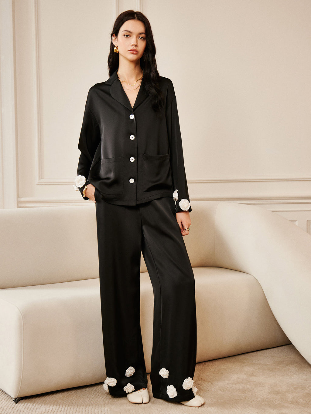 LA FINE FLEUR 3D Floral Print Satin Pants, black with button details and white cuff accents.