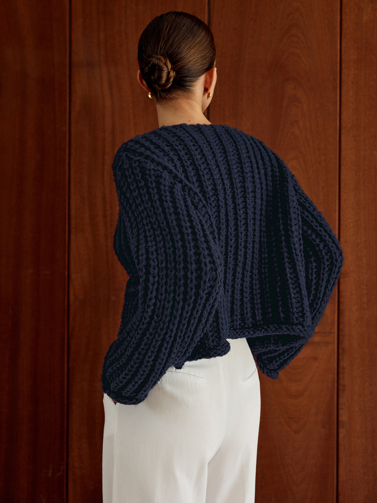Navy blue LA FINE FLEUR Timeless Button-Up Cardigan in Soft Knit paired with white pants.
