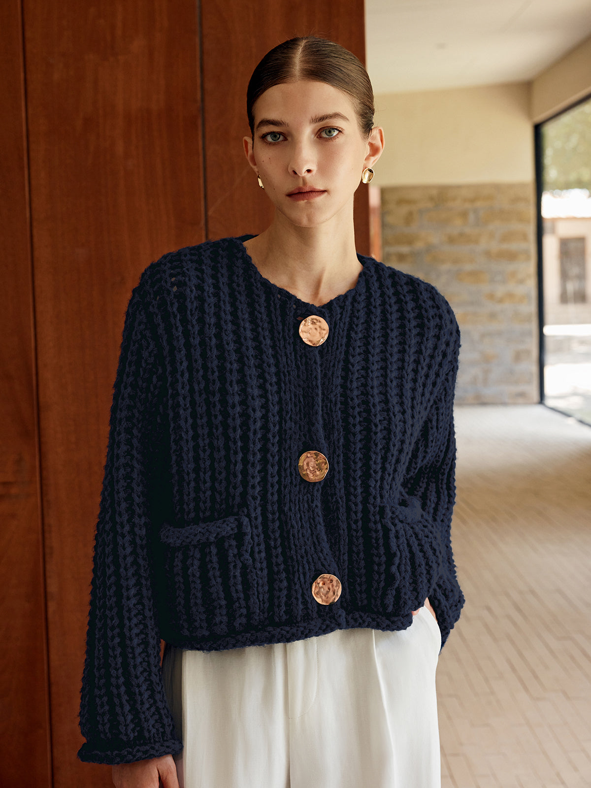 Navy blue soft knit button-up cardigan with large gold buttons and front pockets.