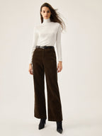 Corduroy wide leg pants with convenient pockets, paired with a white turtleneck and black belt.