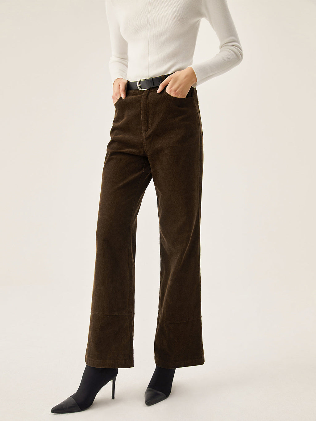 Dark brown corduroy wide leg pants with convenient pockets, styled with a white long-sleeve top.