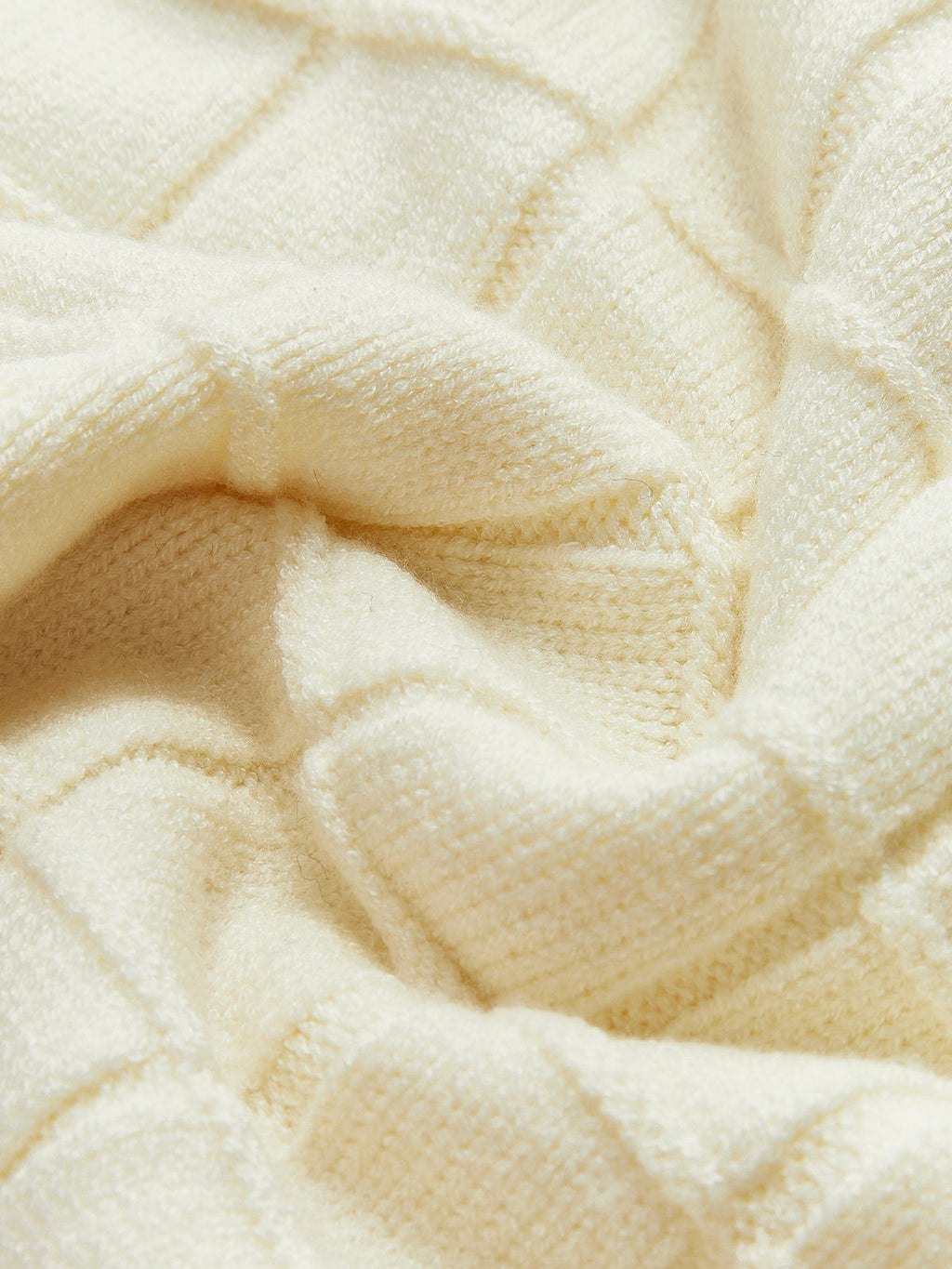 Cream checkered plaid pullover sweater with contrasting trim, softly textured and gently rumpled.