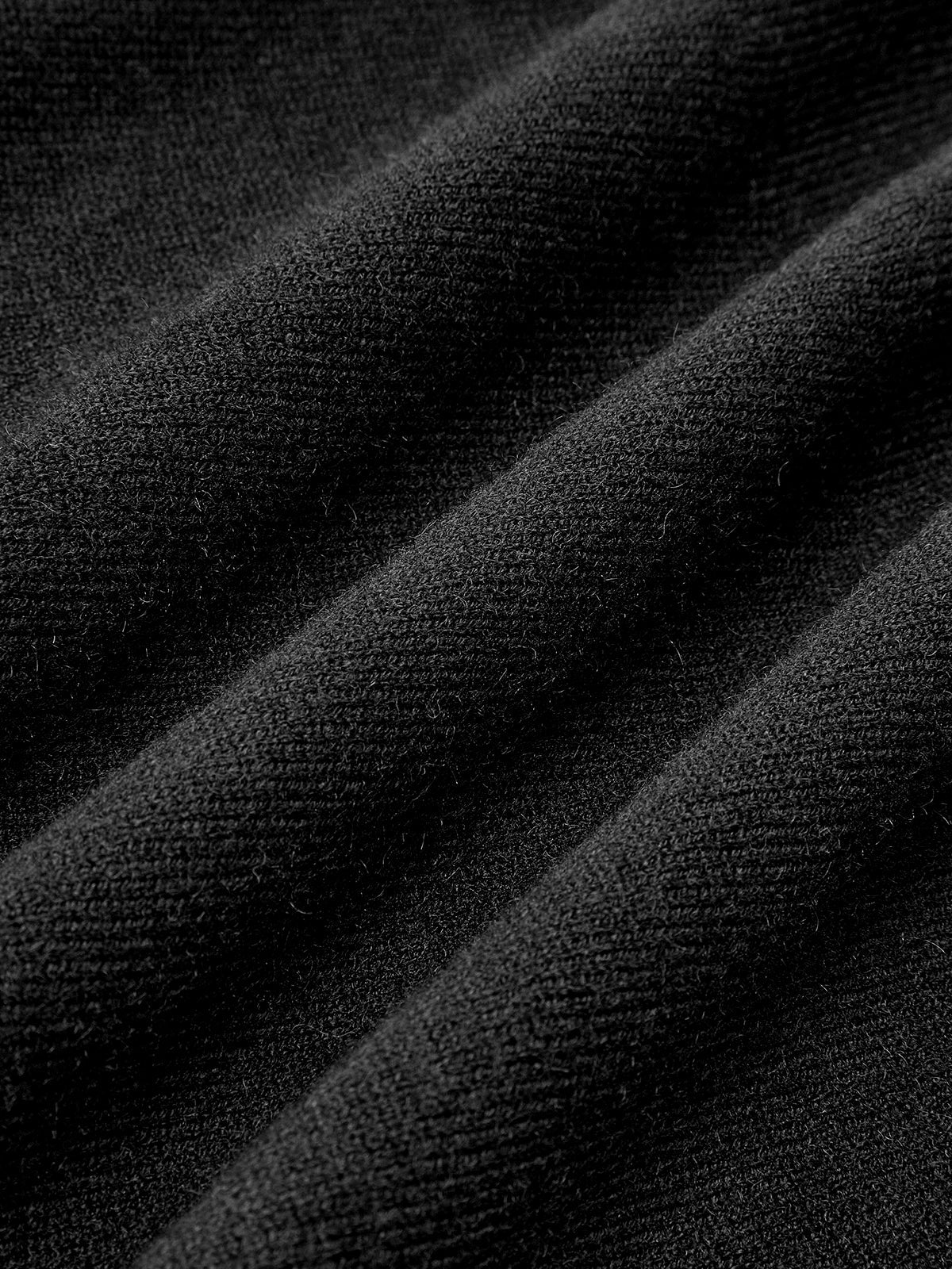 Soft black knit dress with smooth pleats and cozy texture, short hemline, stylish comfort.