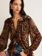 A leopard print blouse with ruffle detail, sheer long sleeves, and classic blue jeans.