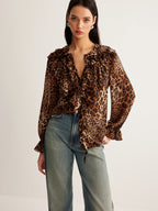 LA FINE FLEUR Leopard Print Blouse with Ruffle Detail paired with high-waisted blue jeans.