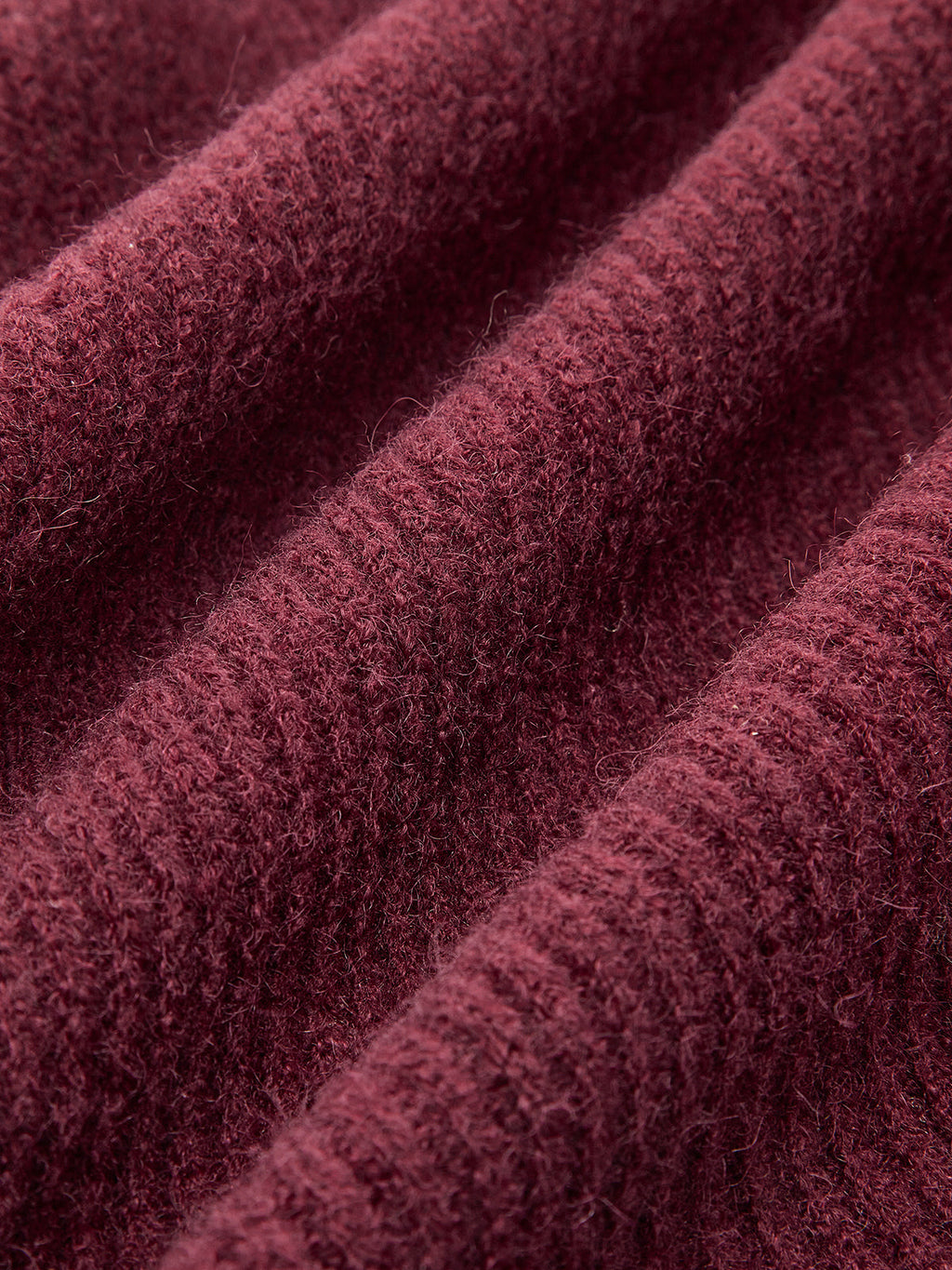 Burgundy ribbed cardigan with lace trim, tie-front bows, and softly waved, fuzzy fabric.