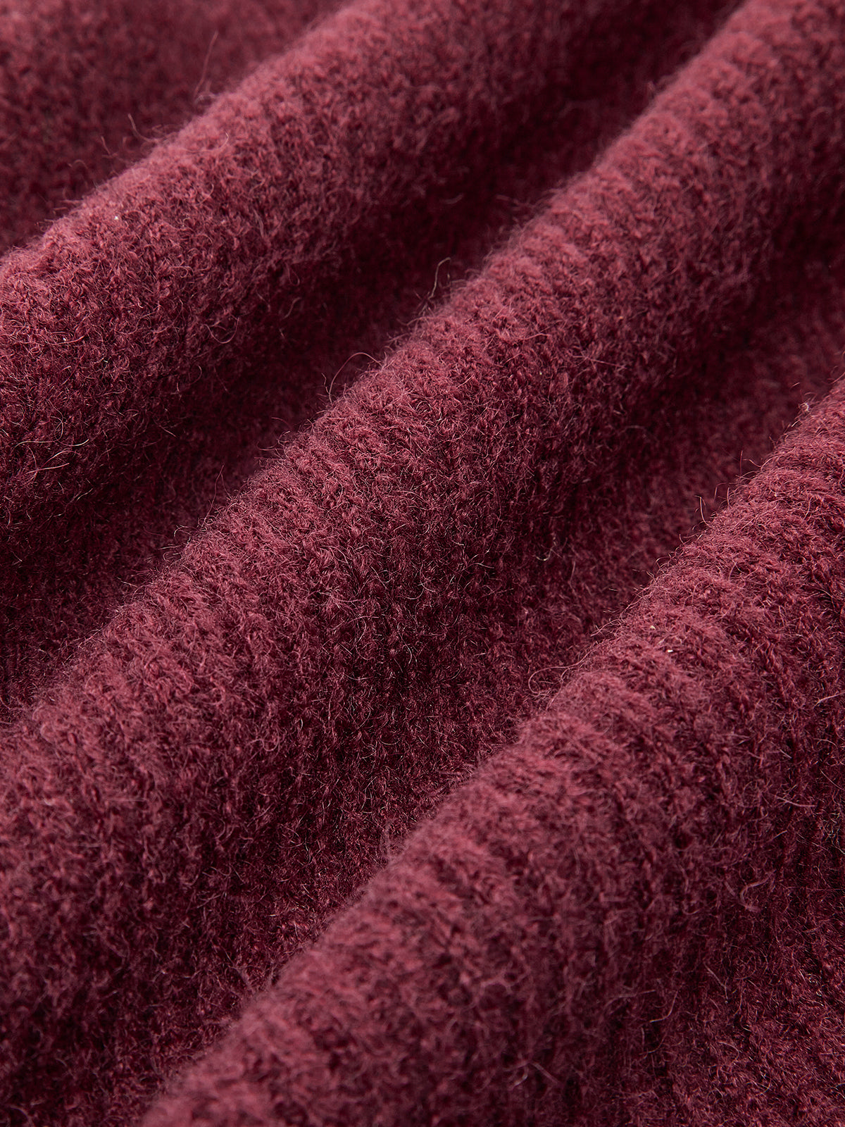 Burgundy ribbed cardigan with lace trim, tie-front bows, and softly waved, fuzzy fabric.