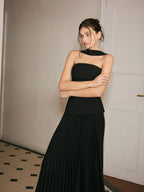 An elegant black sleeveless midi dress featuring a choker neck and pleated front detail.