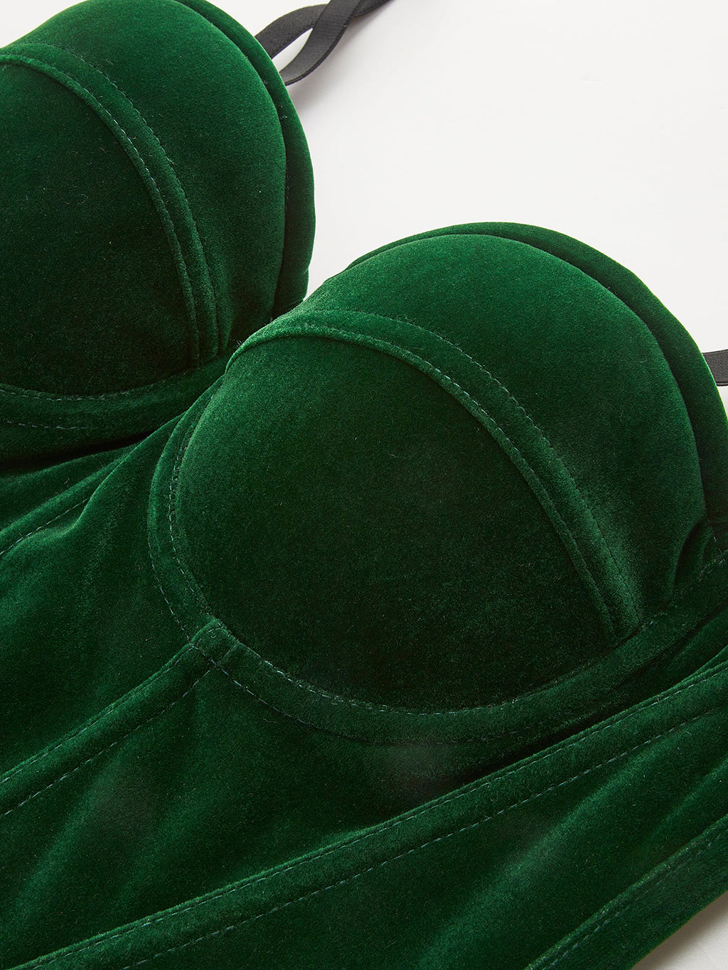 Green velvet sleeveless corset with zipper, piping details, sweetheart neckline, and stitched seams.
