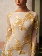 A slim fit, long sleeve mesh dress with bold gold floral appliqué and backless design.