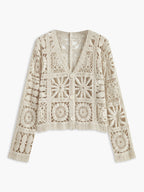 A cream crochet button-up sweater with long sleeves, V-neck, and square patchwork pattern.