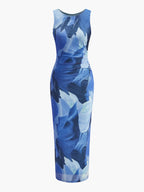Sleeveless bodycon maxi dress with blue-and-white abstract floral print on a white base.