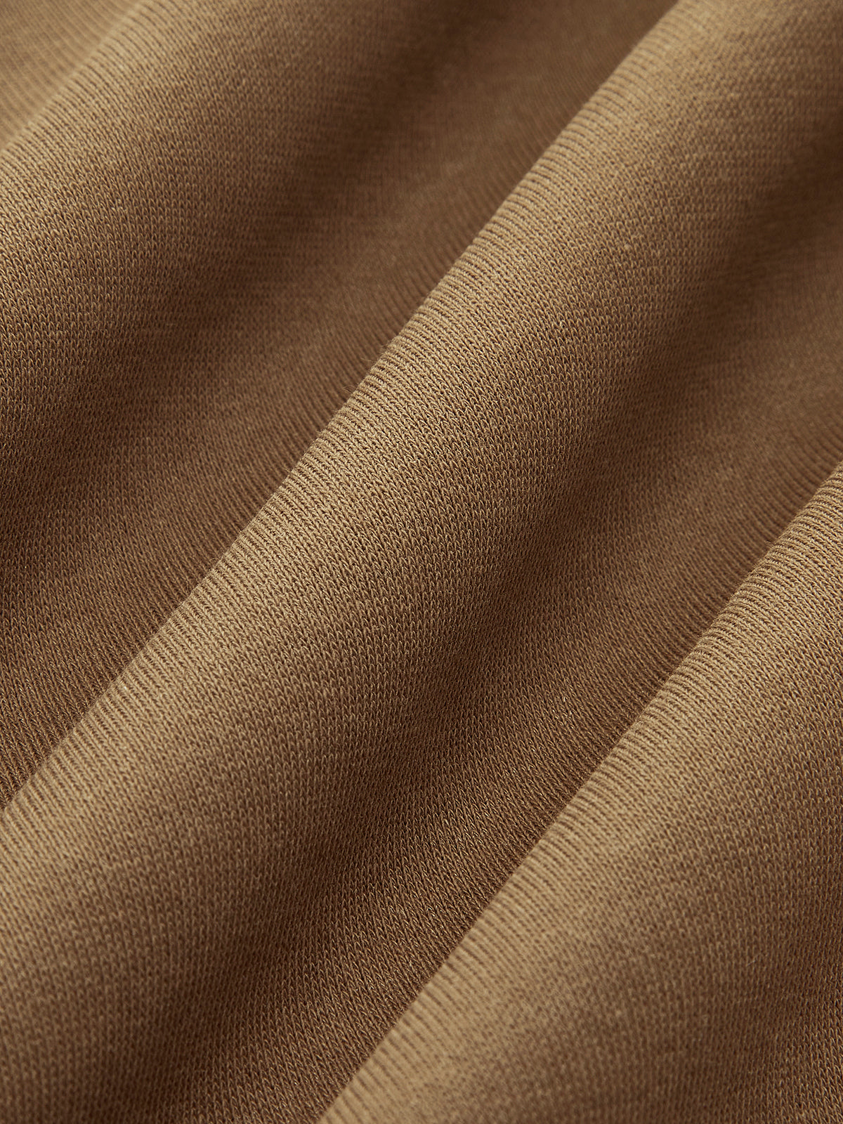 Close-up of brown ribbed knit sweatshirt sweater with wavy folds accentuating fine texture.