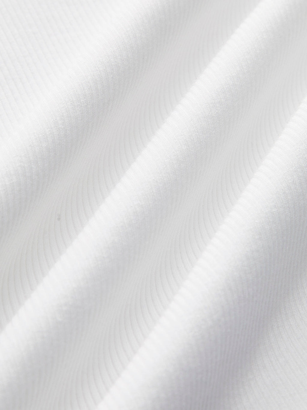 White ribbed Ellis Sleeveless Crop Top with soft diagonal ridges and gentle wavy folds.