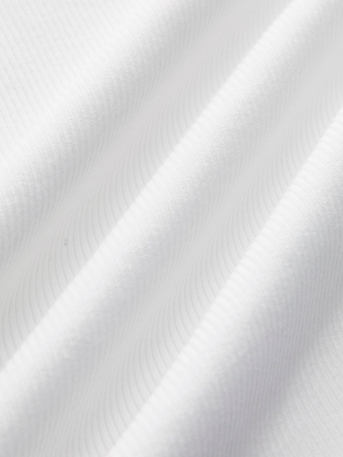 White ribbed Ellis Sleeveless Crop Top with soft diagonal ridges and gentle wavy folds.