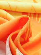 Vibrant orange and yellow tropical sarong skirt with abstract patterns and textured weave.