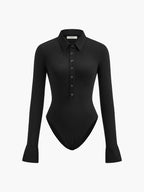 A black, fitted long sleeve bodysuit with a collared neckline and flared cuffs.
