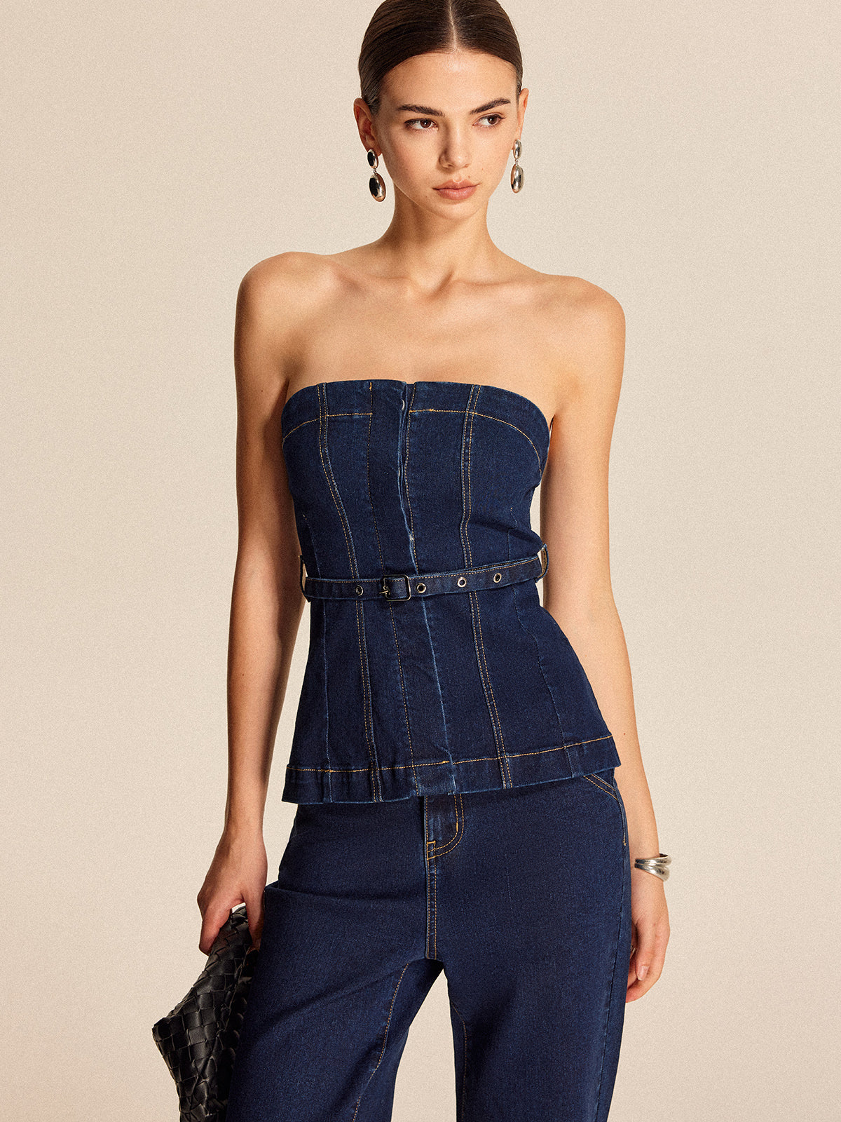 LA FINE FLEUR belted denim strapless top paired with high-waisted jeans.