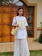 Oversized LA FINE FLEUR cotton print tee with lemon graphic and "AMALFI COAST ITALY" text, long white lace skirt.