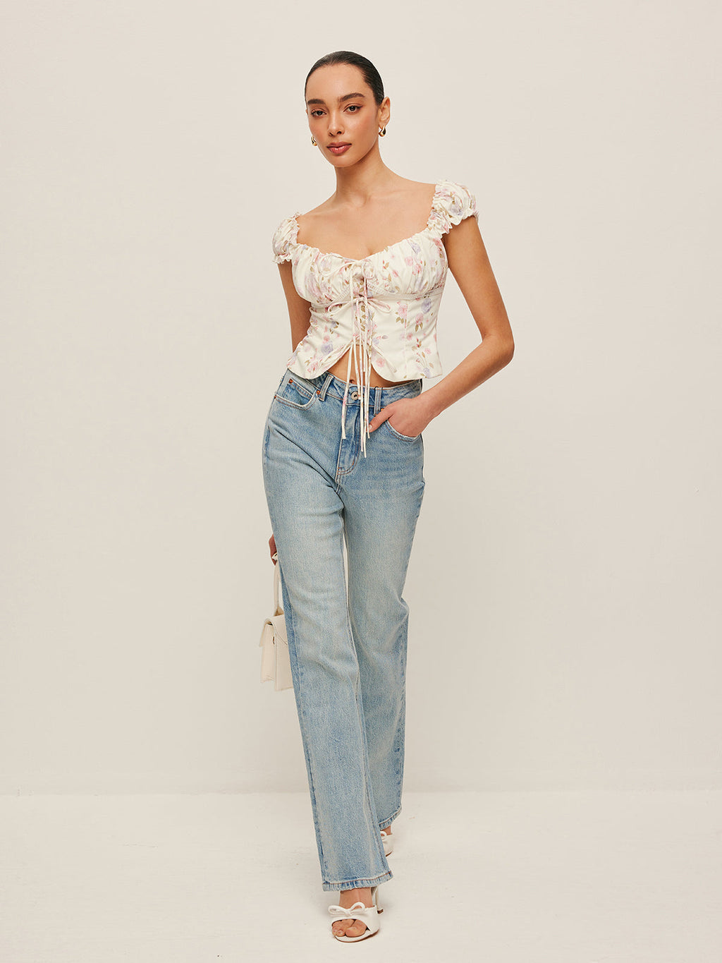 Tie-Front Bustier Top with Ruffled Sleeves and light blue high-waisted jeans.