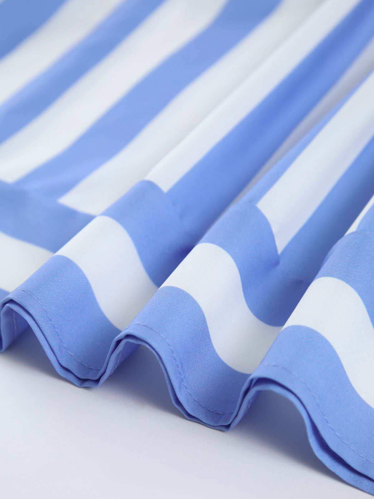 Slim-fit backless long dress with blue and white striped, wavy pleated fabric edges.