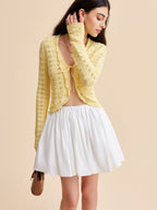 LA FINE FLEUR crocheted cardigan sweater with tie-front, matching top, and white flared skirt.