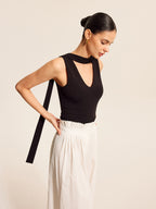 V-Neck blouse with elegant scarf-style neck tie paired with white pleated high-waisted pants.