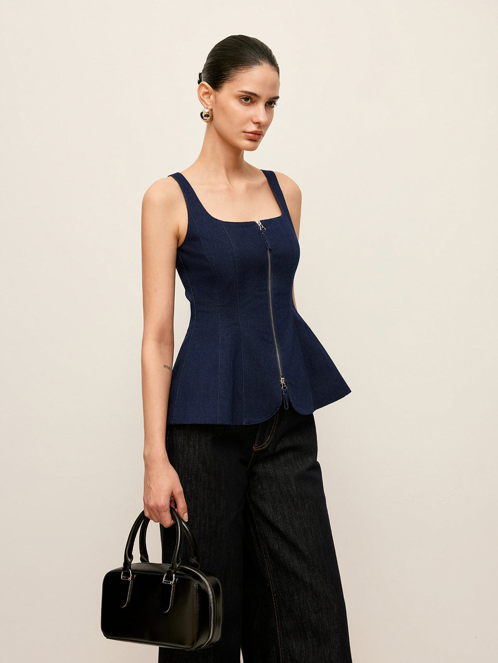 Zip-up denim peplum blouse with stylish waist detail, paired with wide-leg pants.