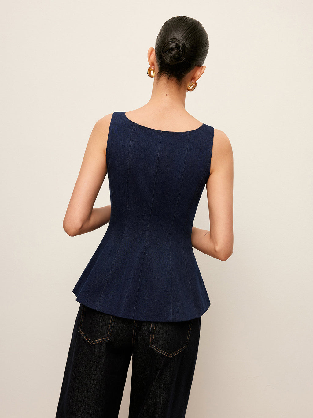 LA FINE FLEUR Zip-Up Denim Peplum Blouse with stylish waist detail, paired with dark pants.