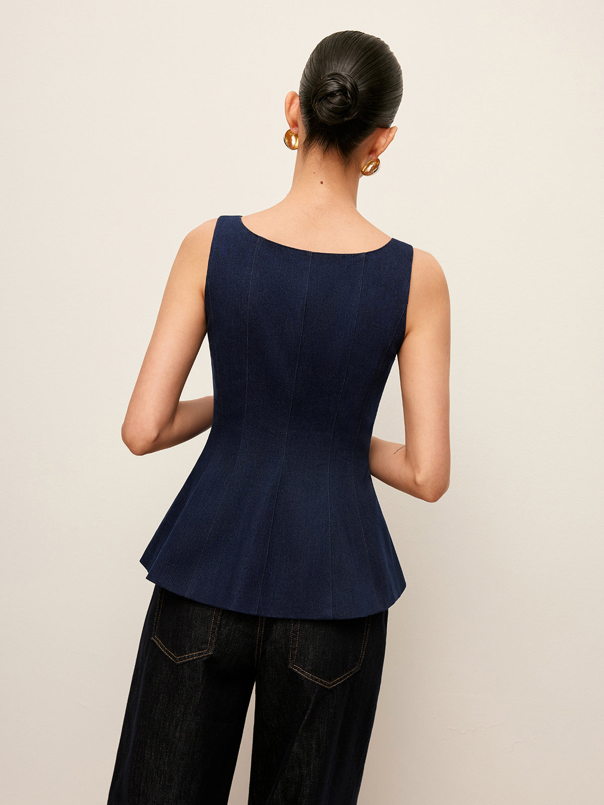 LA FINE FLEUR Zip-Up Denim Peplum Blouse with stylish waist detail, paired with dark pants.