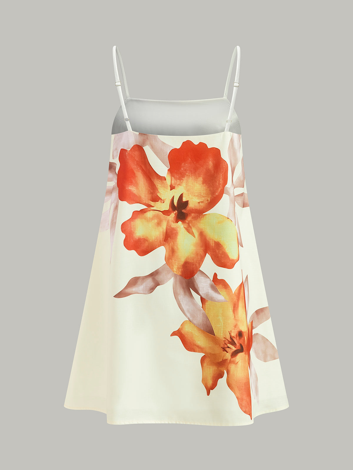 Sleeveless, oversized cream mini dress with white straps and bold orange-yellow floral prints.