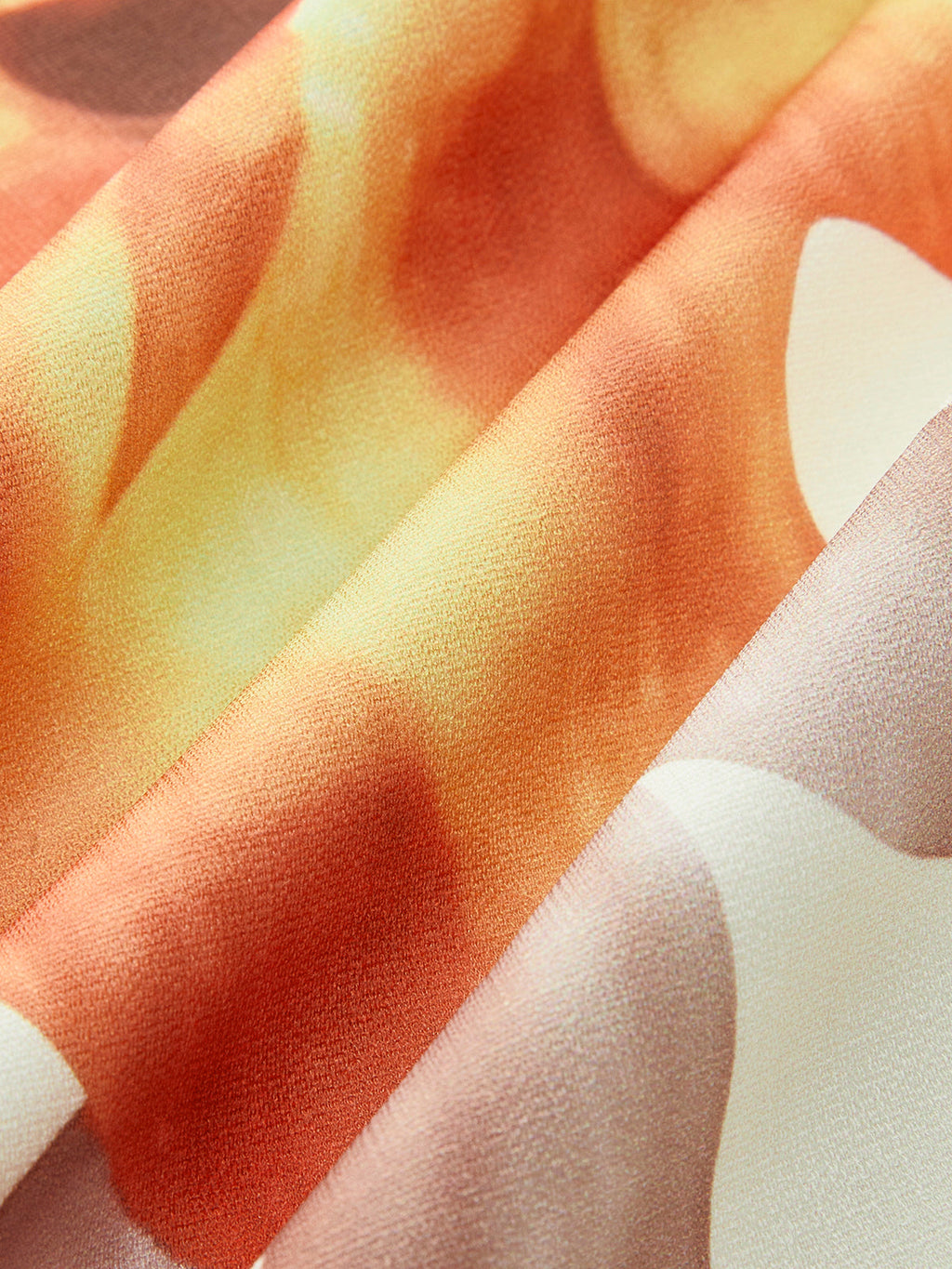Sleeveless, loose-fit dress in soft, semi-sheer fabric with wavy orange-yellow abstract pattern.
