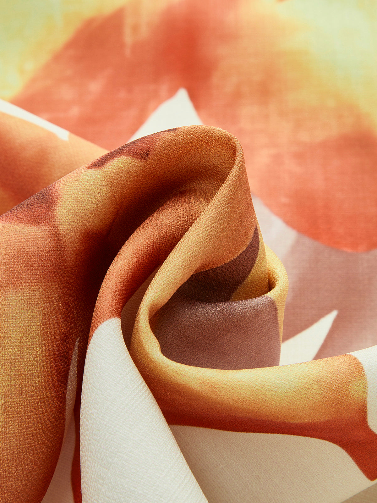Loose-fit dress with orange, yellow, and white abstract print, featuring smooth lightweight fabric.