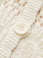 Cream floral crochet cardigan with button-up front and prominent large, round four-hole button.