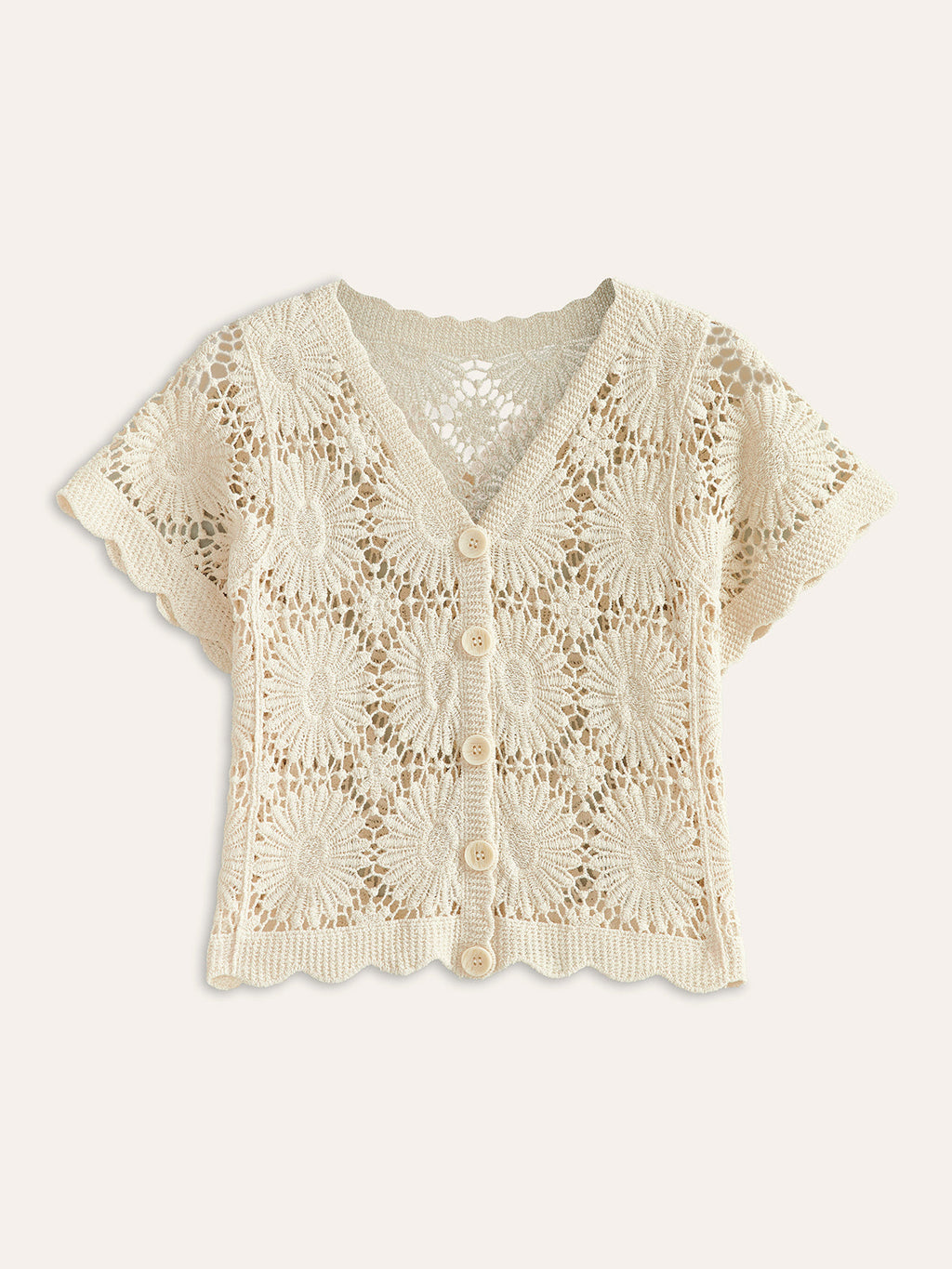 A cropped cream knit cardigan with floral crochet designs, short sleeves, v-neck, button-up front.