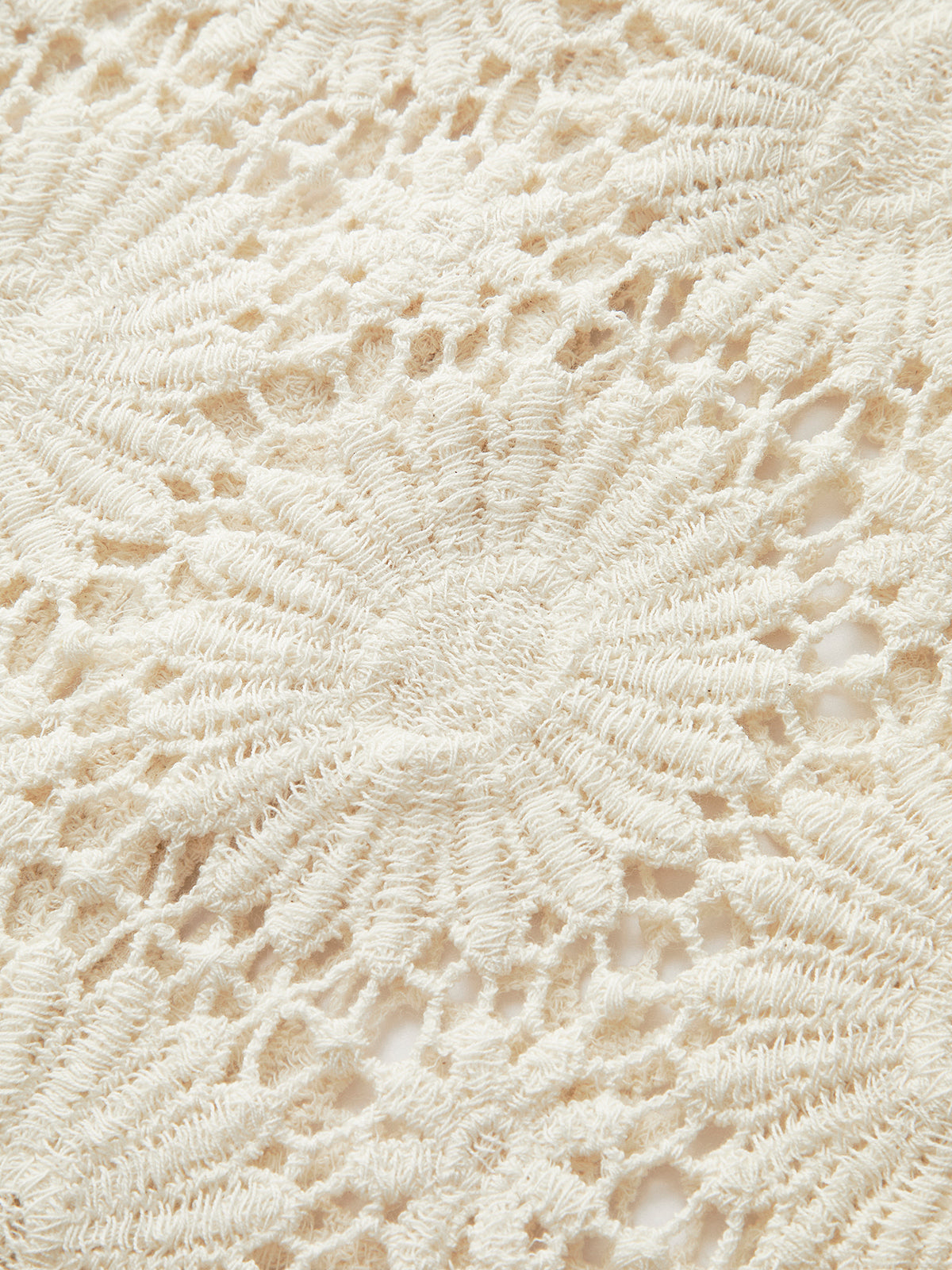 Cream-colored crocheted cardigan with floral lace pattern and intricate button-up design details.