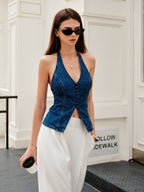 Halter neck denim top with button details paired with white pants.
