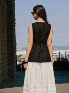 LA FINE FLEUR Linen Vest with elegant button details and a long white skirt.